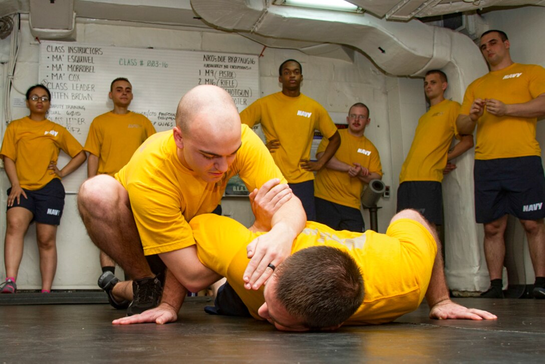 Sailors practice take-down maneuvers in the security training classroom of the USS Dwight D. Eisenhower in the Arabian Gulf, Aug. 4, 2016. The Eisenhower is supporting Operation Inherent Resolve as well as maritime security operations and theater security cooperation efforts in the U.S. 5th Fleet area of responsibility. Navy photo by Seaman Dartez C. Williams