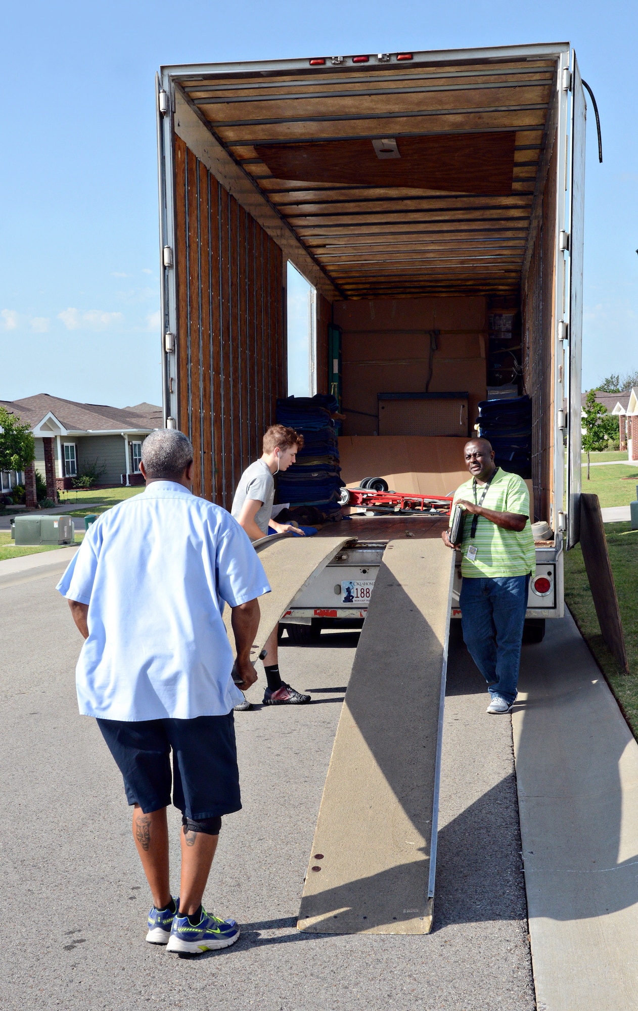 Ronald Jackson, right, a quality assurance inspector with the 72nd Logistics Readiness Squadron’s Personal Property and Passenger Movement Section, talks with members of a moving company as they prepare to load a family’s household belongings during their PCS move. (Air Force photo by Kelly White)