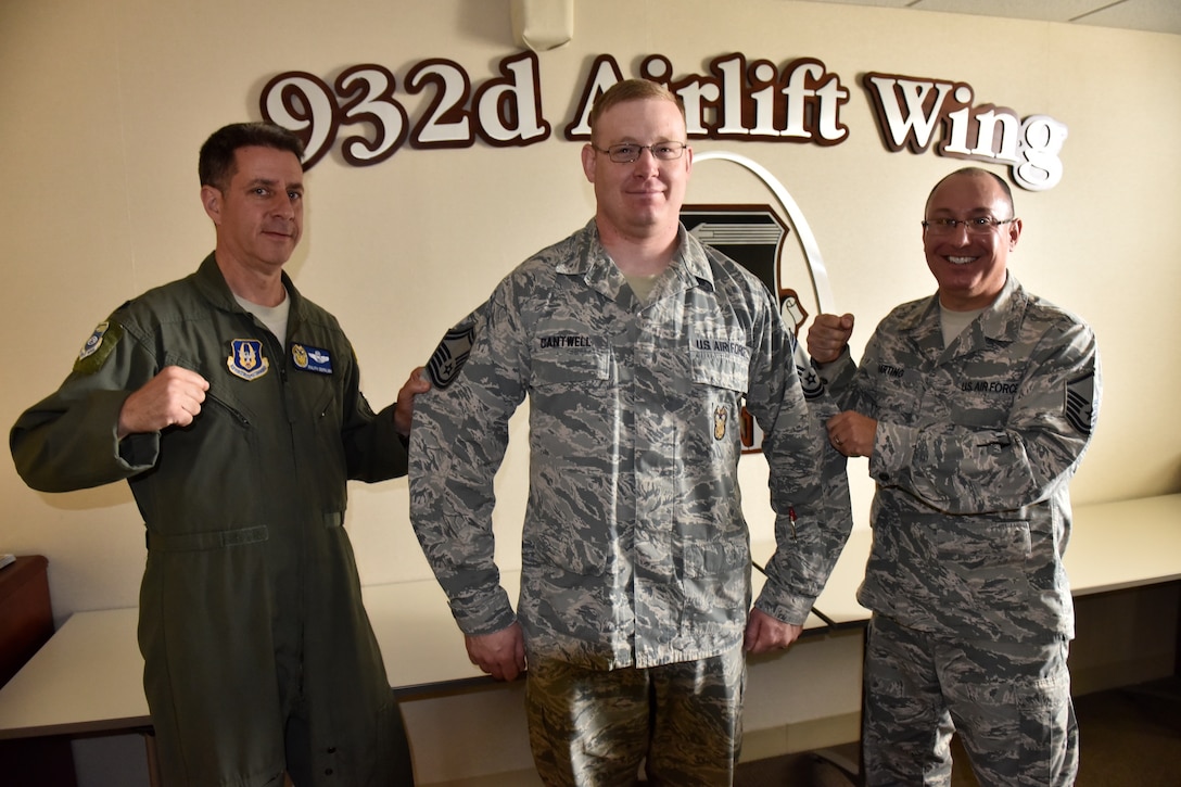 At left, Lt. Col. Ralph DePalma, 932nd Airlift Wing Director of Inspector General-Inspections (IGI) along with Master Sgt. Brent Harting 932nd Logistics Readiness Flight (right), provide the tradition of "tacking on" the new rank to Senior Master Sgt. Wayne Cantwell at the wing headquarters building, Scott Air Force Base, near Bellevillei, Illinois.  (U.S. Air Force photo by Tech. Sgt. Christopher Parr)