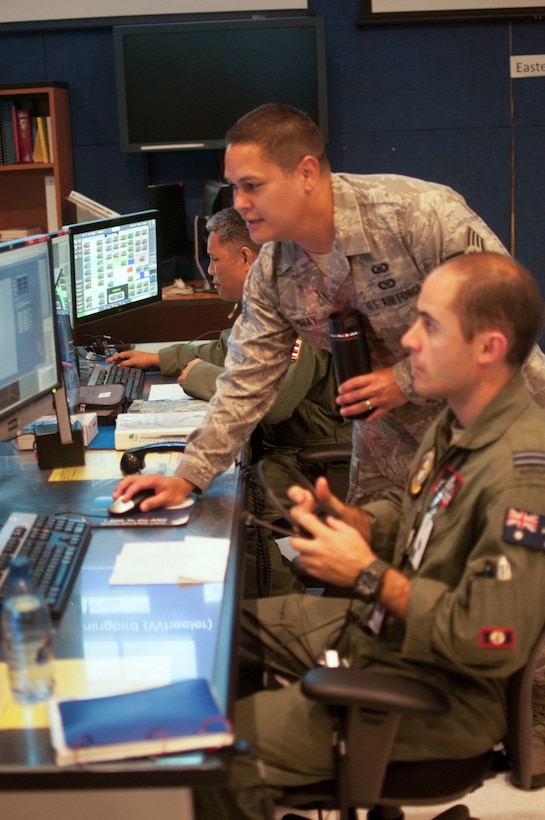 Hawaii Air National Guard Staff Sgt. Adam Bray, 169th Air Defense Squadron weapons director, assists a Royal Australian Air Force service member at Wheeler Army Airfield, Hawaii, July 21, 2016. The 169th ADS exercised with international air defense counterparts during RIMPAC 2016. The international partners included air defense experts from the Royal Canadian Air Force as well as the Royal Australian Air Force. (Air National Guard photo by Airman 1st Class Robert Cabuco/released) 