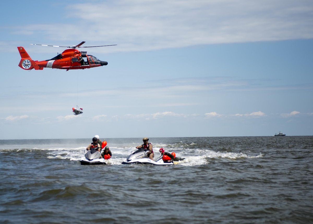 A Dover Air Force Base Airman is basket lifted by a Coast Guard H-65 Dolphin helicopter during water survival training Aug. 6, 2016 at Bowers Beach, Del. Airmen with the 512th and 436th Airlift Wings performed water survival training focusing on treading water, raft survival, and the basket-lift helicopter evacuation. (U.S. Air Force Photo/ Tech. Sgt. Nathan Rivard)