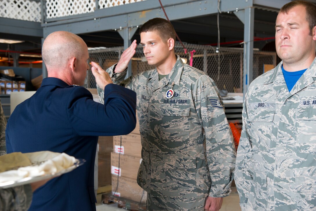 Staff Sgt. Ryan Belfield, a 167th contract specialist and member of the base honor guard, salutes Col. Shaun Perkowski, commander of the 167th Airlift Wing, during a ceremony for newly certified honor guard members at the Martinsburg air base, July 22. (U.S. Air National Guard photo by Senior Master Sgt. Emily Beightol-Deyerle)