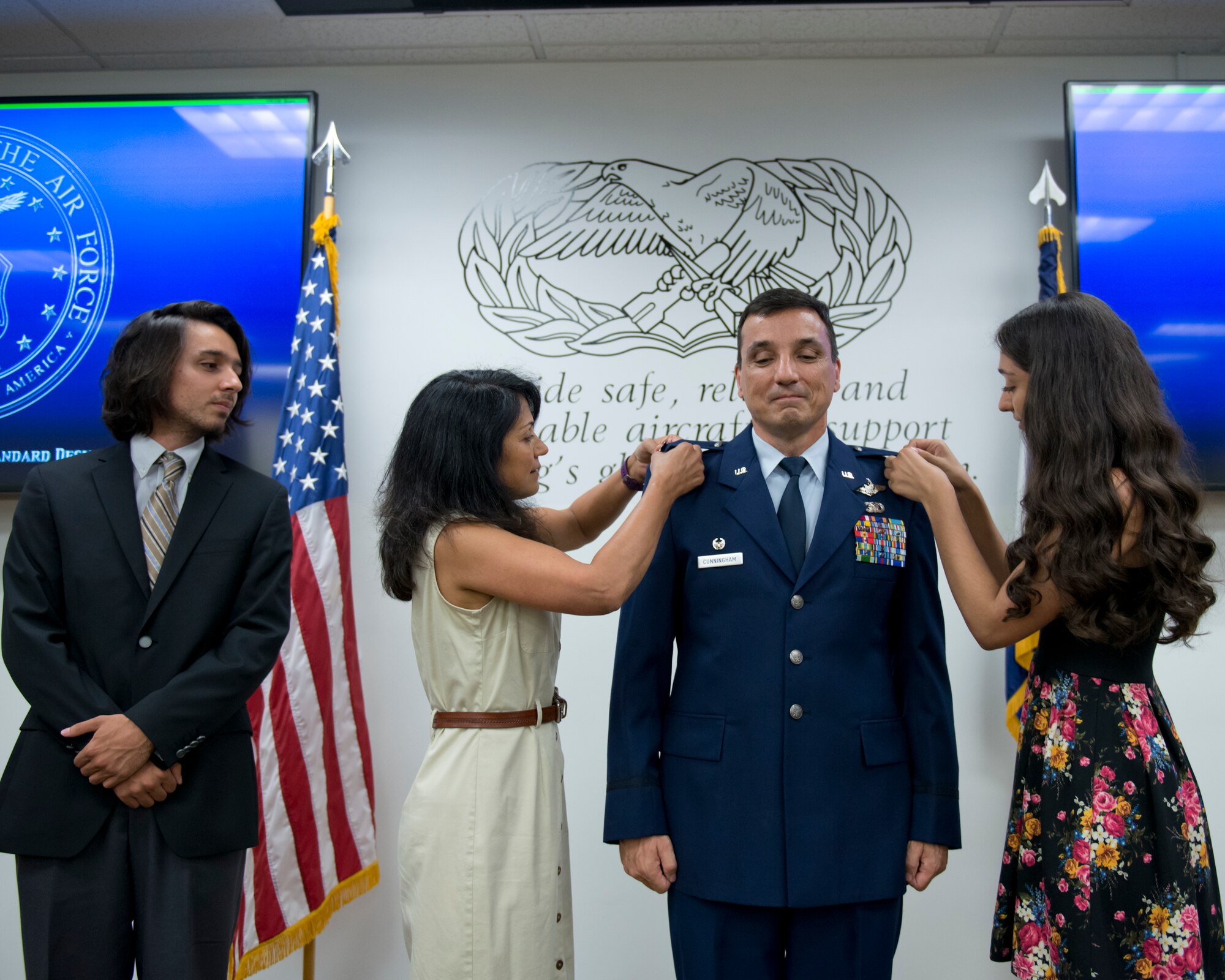 Lt. Col. Christian Cunningham, 167th Maintenance Commander, was promoted to the rank of Colonel during a ceremony at the Martinsburg, W.Va. air base, Aug 6.  Pinning Col. Cunningham was his wife Narmada, his daughter Asha, his son Iain looks on. (U.S. National Guard photo by Tech. Sgt. Michael Dickson)