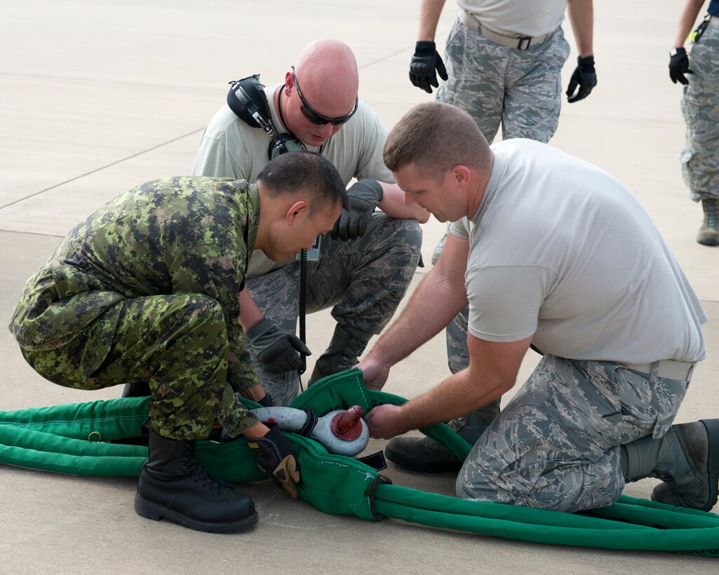 Members of the 167th Maintenance Squadron and the Royal Canadian Air Force assemble a tow rope that connects ground equipment to a C-17 Globemaster III aircraft during a Crashed, Damaged or Disabled Aircraft Recovery training event at the 167th Airlift Wing, Aug 6. Canadian maintainers travelled to the 167th to gain experience on the new crash kit along with members of several other U.S. Air Force units. (U.S. National Guard photo by Tech. Sgt. Michael Dickson)