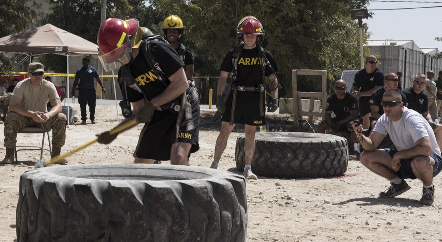 U.S. Army 1st Lt. Carson Davies, 822nd Military Police Detachment, pounds at a tire while competing in the Battle of the Badges competition, Bagram Airfield, Afghanistan, Aug. 7, 2016. Teams of 4 had to endure physical and mental challenges to include a tire lift, sled pull, weapons assembly, dummy carry, shoot-out, tug-of-war and moving a HUMVEE. (U.S. Air Force photo by Tech. Sgt. Tyrona Lawson)