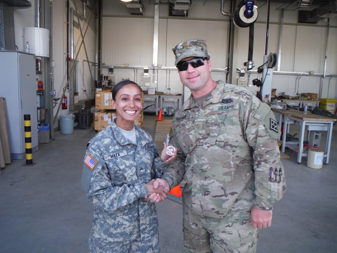Cpl. Amanda Mata, a logistical clerk with the 766th Engineer Company (Horizontal), 841st Engineer Battalion, U.S. Army Reserve, is presented a command team coin for excellence by Maj. Ridenour, Headquarters and Headquarters Company, 841st Engineer Battalion. Mata was recognized for her knowledge and dedication in ensuring administrative functions were handled swiftly and competently. (U.S. Army photo by Capt. Jose F. Lopez Jr., 841st Eng. Bn., United States Army Reserve)