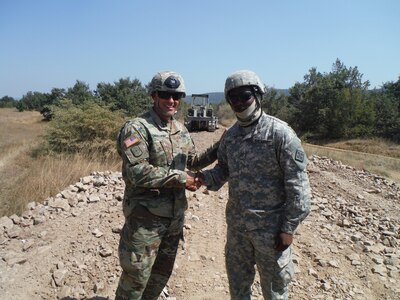 Pvt. Alvin George, a heavy equipment operator with the 766th Engineer Company (Horizontal), 841st Engineer Battalion, U.S. Army Reserve, is presented a command team coin for excellence by Maj. Chrustowski, Headquarters and Headquarters Company, 841st Engineer Battalion. George was recognized for his skill in operating a bulldozer in a safe and efficient manner. (U.S. Army photo by Capt. Jose F. Lopez Jr., 841st Eng. Bn., United States Army Reserve)