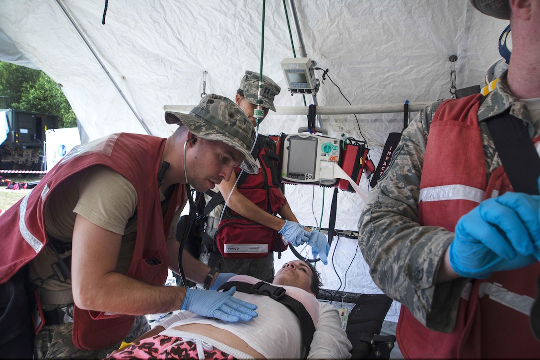 Airmen treat a role-playing patient during Vigilant Guard 2016 at Camp Johnson, Colchester, Vt., July 30, 2016. The airmen are assigned to the New Hampshire National Guard’s 157th Medical Group. Air National Guard photo by Airman 1st Class Jeffrey Tatro 