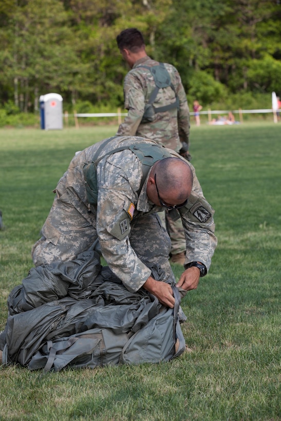 U.S. Army Reserve Paratrooper Staff Sgt. Edward Reagan, 982nd Combat Camera Company (Airborne), puts his parachute into a Universal Parachutist Kit Bag during Leapfest 2016 in West Kingston, R.I., August 4, 2016. Leapfest is an International parachute training event and competition hosted by the 56th Troop Command, Rhode Island Army National Guard to promote high level technical training and esprit de corps within the International Airborne community. (U.S. Army photo by Sgt. Brady Pritchett / Released)