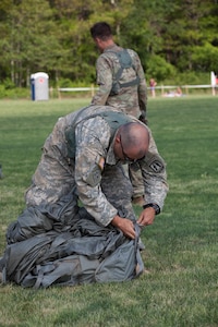 U.S. Army Reserve Paratrooper Staff Sgt. Edward Reagan, 982nd Combat Camera Company (Airborne), puts his parachute into a Universal Parachutist Kit Bag during Leapfest 2016 in West Kingston, R.I., August 4, 2016. Leapfest is an International parachute training event and competition hosted by the 56th Troop Command, Rhode Island Army National Guard to promote high level technical training and esprit de corps within the International Airborne community. (U.S. Army photo by Sgt. Brady Pritchett / Released)