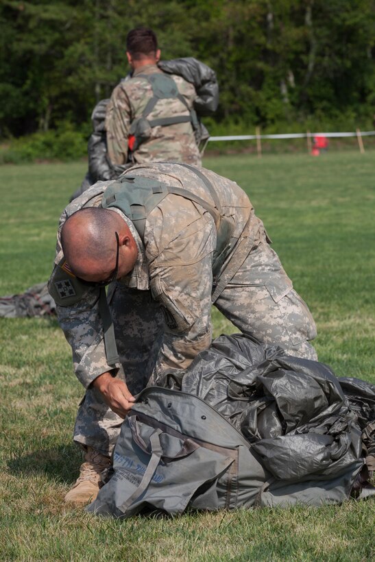 U.S. Army Reserve Paratrooper Staff Sgt. Edward Reagan, 982nd Combat Camera Company (Airborne), puts his parachute into a Universal Parachutist Kit Bag during Leapfest 2016 in West Kingston, R.I., August 4, 2016. Leapfest is an International parachute training event and competition hosted by the 56th Troop Command, Rhode Island Army National Guard to promote high level technical training and esprit de corps within the International Airborne community. (U.S. Army photo by Sgt. Brady Pritchett / Released)