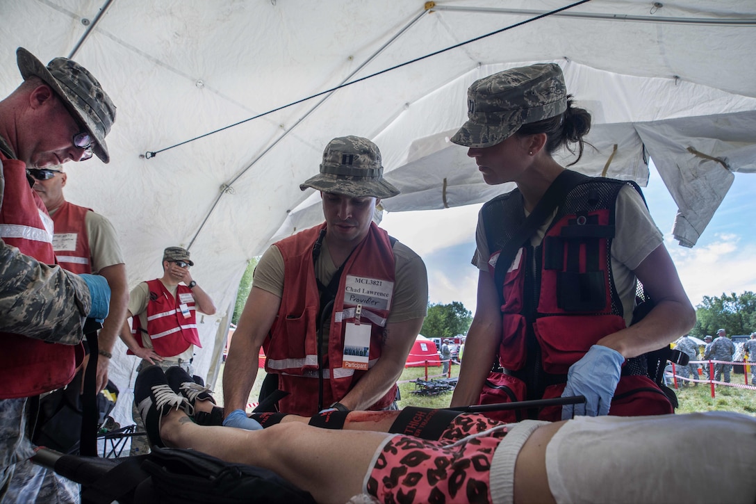 Airmen treat a role-playing patient during Vigilant Guard 2016 at Camp Johnson, Colchester, Vt., July 30, 2016. Air National Guard photo by Airman 1st Class Jeffrey Tatro