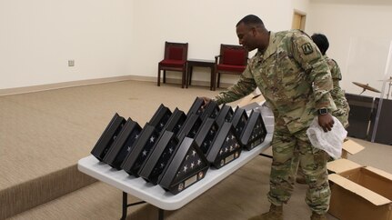 Army Reserve Chief Warrant Officer 2 Terrance L. Coleman, personnel readiness chief, 335th Signal Command (Theater), arranges American flag display cases that were later presented to Army Reserve Soldiers from Detachment 11, 335th SC (T), during a Welcome Home Warrior Ceremony at North Fort Hood, Texas Aug. 3. The detachment of 24 Soldiers spent the last nine months deployed to Afghanistan in support of Operation Enduring Freedom and the ongoing war on terrorism. Their mission comprised of providing, maintaining, repairing and establishing electronic communications throughout the Afghan theater of operations.