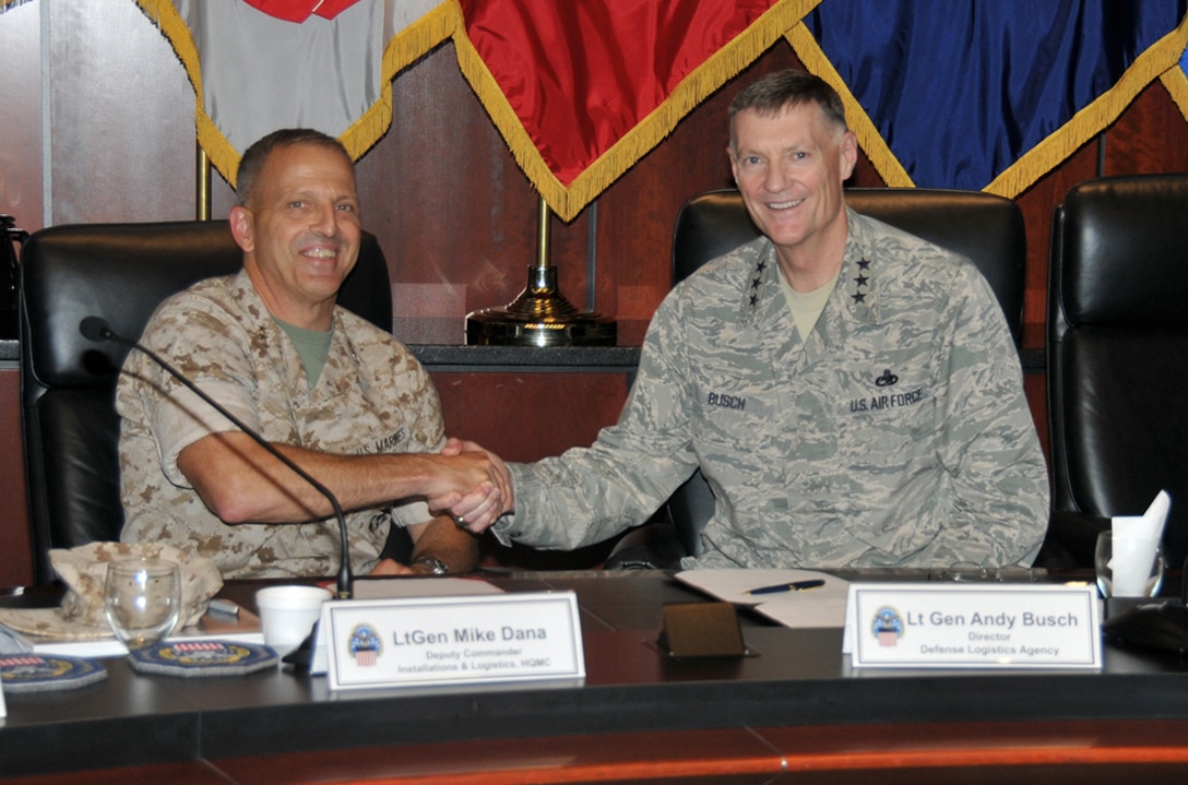 Marine Corps Lt. Gen. Mike Dana (left), Deputy Commandant, Installations and Logistics clasps hands with DLA Director Air Force Lt. Gen. Andy Busch after signing the Performance Based Agreement 2016, which enhances the DLA/Marine Corps partnership over the next three years.