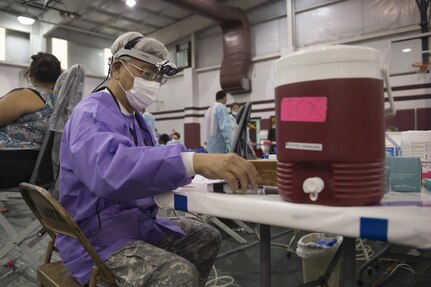 Lt. Col. John Hsu, a dentist in the 804th Medical Brigade, U.S. Army Reserves, Operations Chief for Dental Services, prepares to treat a patient at an Operation Lone Star site in Pharr, Texas, July 27, 2016. Service members from the Texas State Guard worked alongside Soldiers from the 804th Medical Brigade, U.S. Army Reserves, the Texas Department of Public Safety, the Department of State Health Services, Remote Area Medical volunteers, Cameron County Department of Health and Human Services (DHHS), City of Laredo Health Department, Hidalgo County DHHS and U.S. Public Health Services during Operation Lone Star (OLS), a week long real-time, large-scale emergency preparedness exercise in La Joya, Pharr, Brownsville, Rio Grande City and Laredo, Texas, July 25-29, 2016. OLS is an annual medical disaster preparedness training exercise, uniting federal, state and local health and human service providers, that addresses the medical needs of thousands of underserved Texas residents every year. (U.S. Army National Guard photo by Sgt. 1st Class Malcolm McClendon)