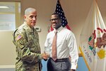 Command Sgt. Maj. Mark Bowman, Land Component Command Sergeant Major, Illinois Army National Guard, shakes hands with Sgt. Joshua Isom, of Chicago, Aug. 3, 2016, at Camp Lincoln, Springfield, Illinois, after an enlistment ceremony.