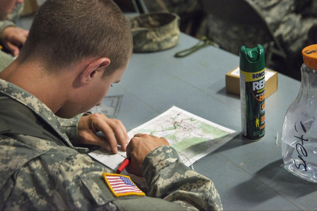 A soldier plots coordinates on a map during land navigation training at Vigilant Guard 2016 at Camp Ethan Allen Training Site, Jericho, Vt., July 28, 2016. Air National Guard photo by Airman 1st Class Jeffrey Tatro