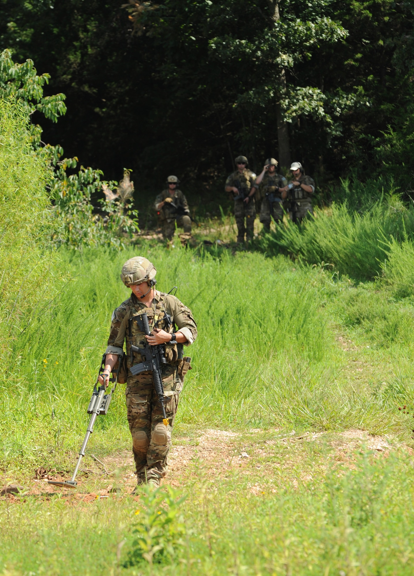 U.S. Air Force Senior Airman Conner Walsh, an explosive ordnance disposal team member assigned to the 509th Civil Engineer Squadron, clears a safe path during the Operation Thunder Weasel exercise at the Truman Lake National Guard Training Site, Mo., July 27, 2016. Teams were required to clear a safe path in order to locate and render safe any improvised explosive devices. (U.S. Air Force photo by Senior Airman Danielle Quilla)
