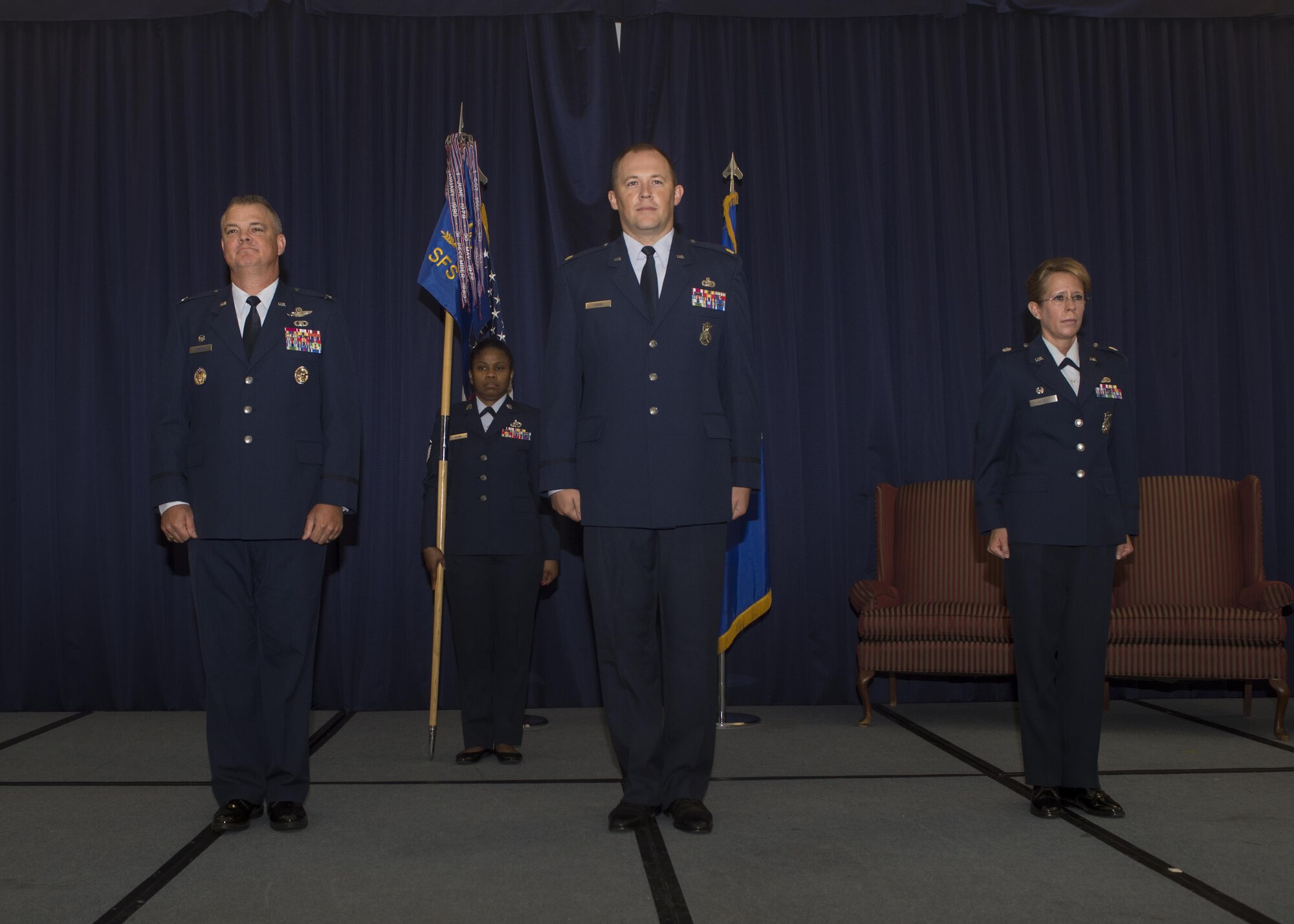 Lt. Col. Jennifer Aquinas, outgoing 512th Security Forces Squadron commander, relinquishes her command to incoming commander, Maj. Alexander Logan, during a change of command ceremony Aug. 6, 2016, Dover Air Force Base, Del. 