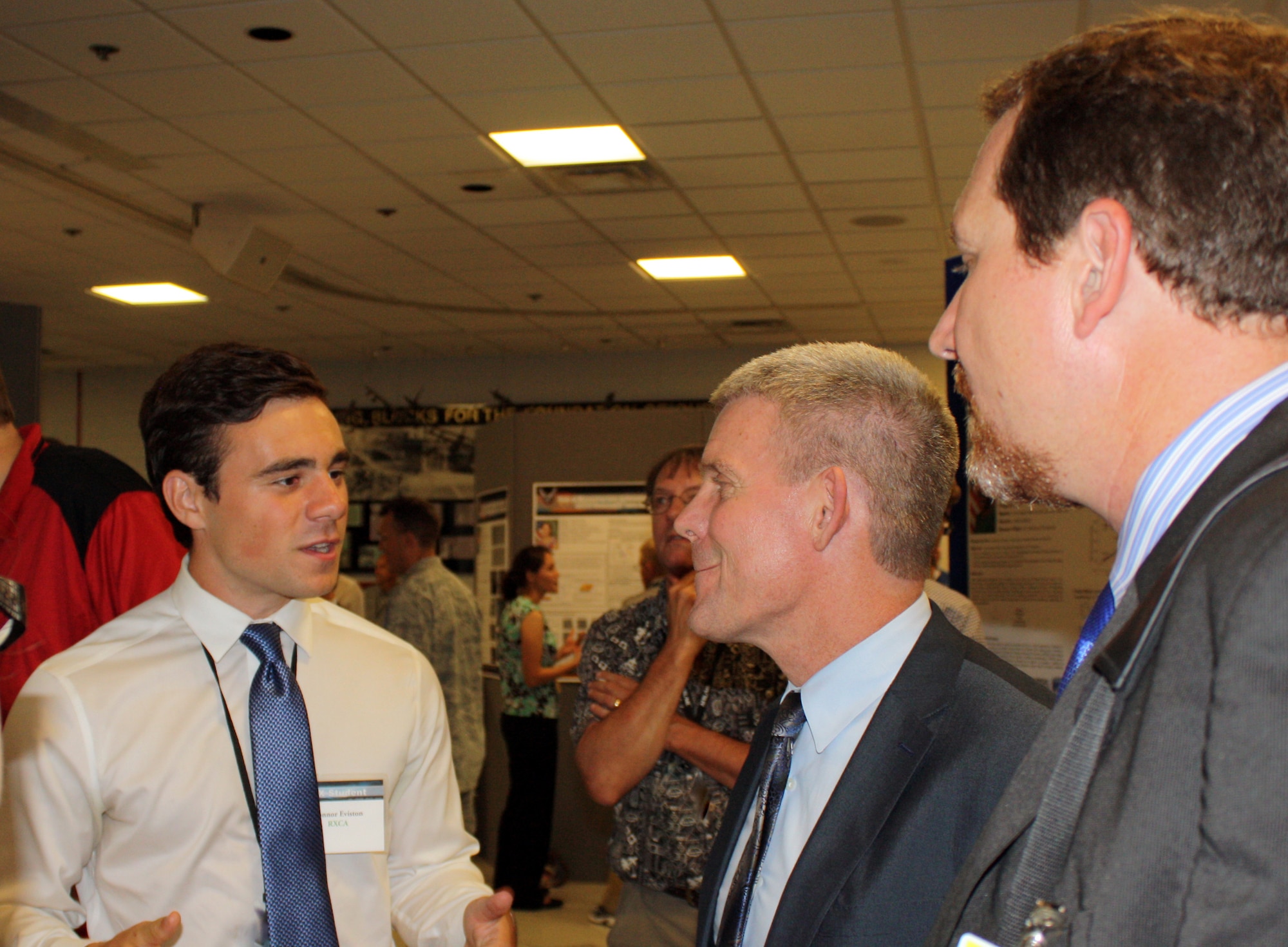 Thomas Lockhart (center), Director, AFRL Materials and Manufacturing Directorate, and Chad Watchorn (right), Executive Director, Regional STEM Collaborative, speak with interns Connor Eviston and Megan Imel (unpictured), undergraduate students from the University of Cincinnati and Wright State University, respectively, during the 2016 RX Summer Student Poster Session, Aug. 5. Eviston and Imel researched nondestructive evaluation and thermal signals for impact-damaged polymer matrix composites this summer. (U.S. Air Force photo/Marisa Novobilski)