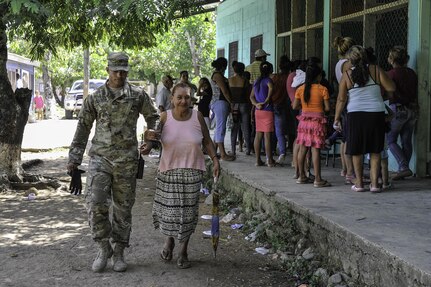 U.S. Army Pvt. Gabriel Hassoun, Joint Task Force-Bravo Army Forces, walks with an elderly woman during a Medical Readiness Training Exercise operation in Trujillo, Honduras, July 29, 2016. While MEDRETEs greatly help the local populations where they are conducted, the service members executing the operations also receive valuable medical training and experience that comes from operating in remote and/or austere environments. (U.S. Air Force photo by Staff Sgt. Siuta B. Ika)