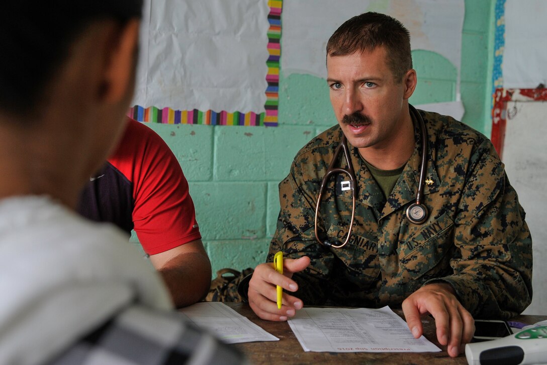 U.S. Navy Lt. Pierre Cagniart, Special Purpose Marine Air-Ground Task Force flight surgeon, speaks with a young woman during a Medical Readiness Training Exercise operation in Trujillo, Honduras, July 29, 2016. The mission objectives of MEDRETEs include providing U.S. military personnel training in delivery of medical care in austere conditions, promoting diplomatic relations between the U.S. and host nations in Central America, and providing humanitarian and civic assistance via a long-term proactive program.  (U.S. Air Force photo by Staff Sgt. Siuta B. Ika)