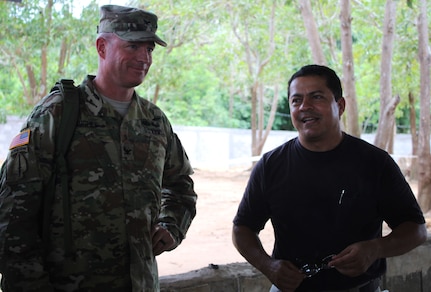 Dr. Wilmer Amador, Joint Task Force-Bravo Honduran Medical Liaison (right), stands next to U.S. Army Col. Brian Hughes, Joint Task Force-Bravo commander, as he explains the different services and provides a tour of the site for key leaders from both JTF-Bravo and Honduras, during a Medical Readiness Training Exercise in the village of La Boveda, Trujillo, July 29, 2016. As the LNO, Amador coordinates mostly with non-profit organizations such as the Ministry of Health, and also coordinates with the Honduran military, school teachers and school principals. (U.S. Army photo by Maria Pinel)