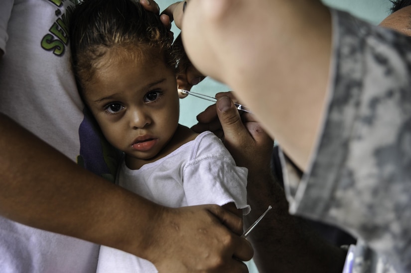 A young girl has her ear inspected by U.S. Army Spc. Kerry Holmes, Joint Task Force-Bravo Medical Element medic, during a Medical Readiness Training Exercise operation in Trujillo, Honduras, July 29, 2016. MEDEL conducts MEDRETEs throughout Central America to provide a variety of medical services to the local populations, who otherwise would be unable to receive medical care from licensed providers. (U.S. Air Force photo by Staff Sgt. Siuta B. Ika)