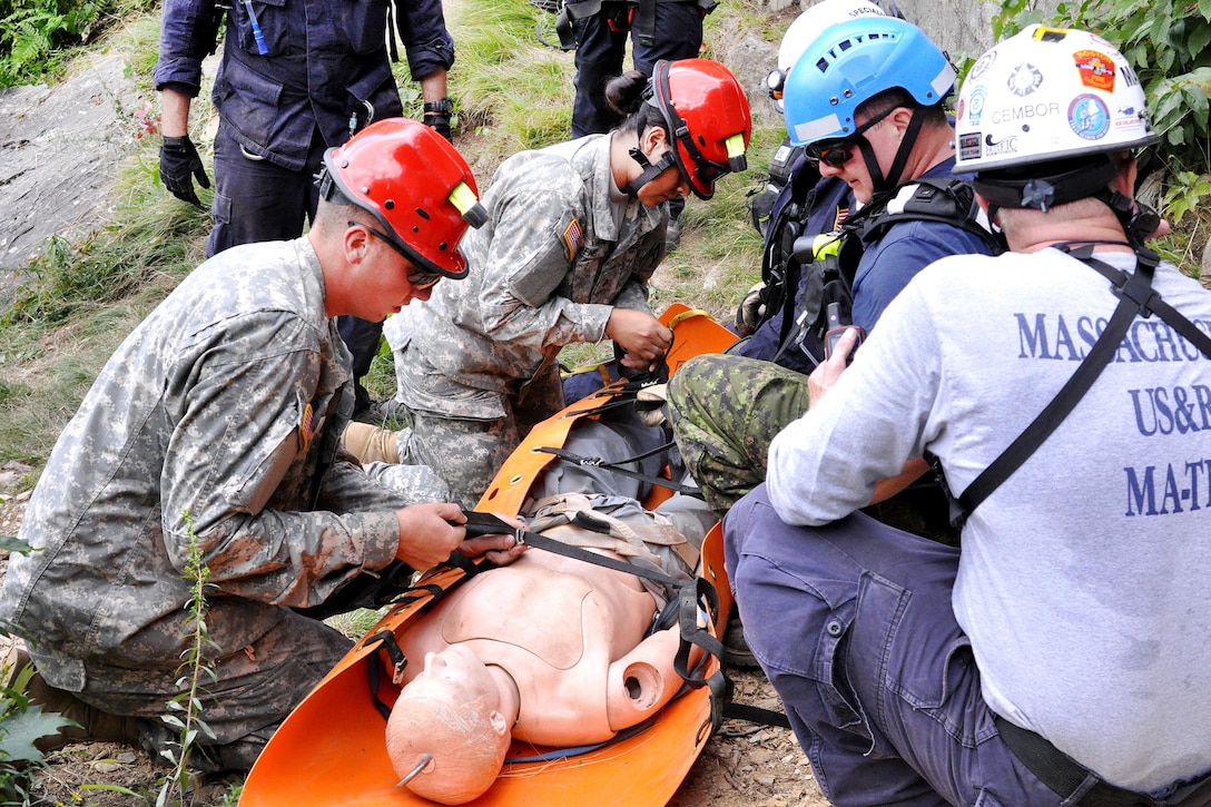 Army Spc. Alex Buckley, left, and Army Pfc. Geraldine Jimenez work with civilian search and rescue teams to secure a simulated casualty during Vigilant Guard 2016 at Camp Ethan Allen Training Site, Jericho, Vt., July 30, 2016. Buckley is a wheeled vehicle mechanic assigned to the Massachusetts National Guard’s 181st Engineer Battalion. Jimenez is a truck driver assigned to the Massachusetts National Guard’s Forward Support Company, 101st Engineers. The National Guard and U.S. Northern Command sponsor the emergency response exercise, which provides an opportunity for service members to improve cooperation with civilian, military and federal partners as they prepare for emergencies and catastrophic events. Army National Guard photo by Staff Sgt. Ashley Hayes
