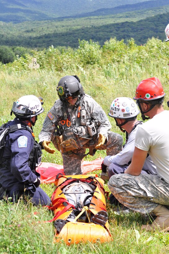 Army Staff Sgt. Stephen Trala, center, talks with civilian search and rescue teams and soldiers during a search-and-rescue exercise as part of Vigilant Guard 2016 at Camp Ethan Allen Training Site, Jericho, Vt., 2016. Trala is a flight medic assigned to Company C, 3rd Battalion, 126th Aviation Regiment Air Ambulance. Army National Guard photo by Staff Sgt. Ashley Hayes