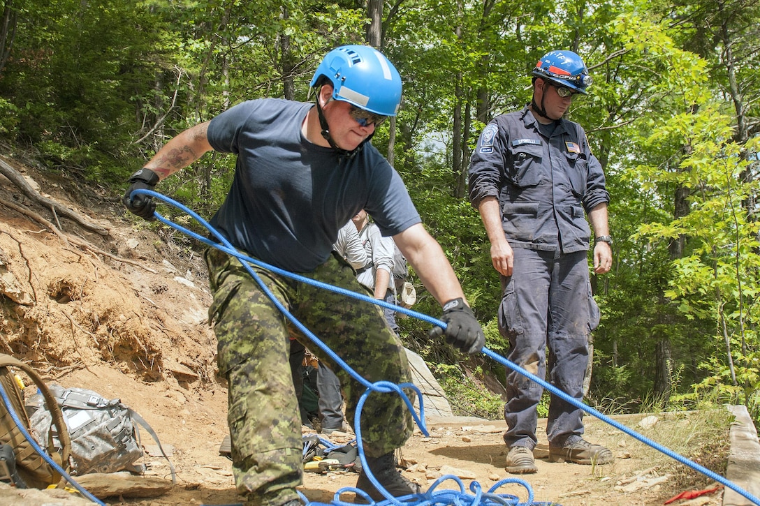 Canadian air force Cpl. Dusty Kennedy, left, hauls gear up a cliff to be used for a search-and-rescue operation during Vigilant Guard 2016 at Camp Ethan Allen Training Site, Jericho, Vt., July 29, 2016. Army National Guard photo by Spc. Avery Cunningham