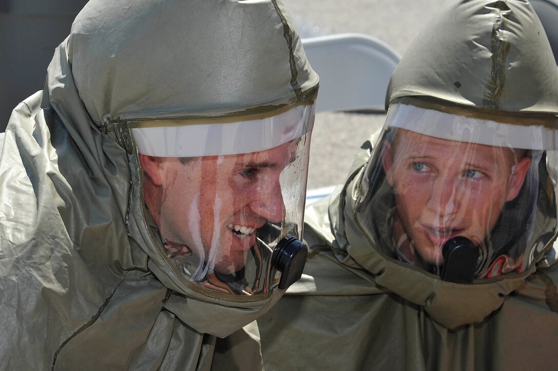 Airmen assigned to the 22nd Medical Group communicate while working on a patient during integrated in-place patient decontamination training, Aug. 4, 2016, at McConnell Air Force Base, Kan. During the exercise, the Airmen set up a complete decontamination system, donned real protective gear, triaged and decontaminated patients. (U.S. Air Force photo/Airman Erin McClellan)