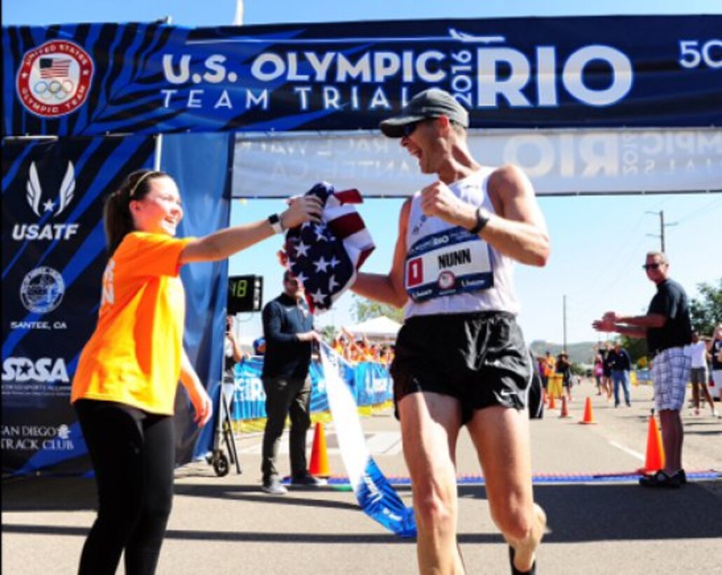 U.S. Army World Class Athlete Program race walker Staff Sgt. John Nunn receives an American flag from his daughter Ella after winning the 2016 U.S. Olympic Team Trials for the 50-kilometer race walk February 21, 2016, in Santee, California. Nunn won the event with a personal-best time of 4 hours, 3 minutes, 21 seconds on the 31-mile course to earn his third Olympic berth. (U.S. Army photo by Tim Hipps) (Photo Credit: Courtesy Photo)