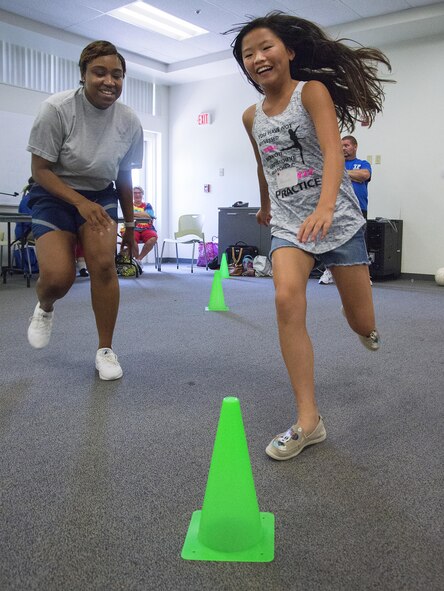 Hannah Haley, 11, and Airman 1st Class Whitney Parker, 88th Medical Operations Squadron administrative technician, race from cone-to-cone in a game at Stop Bullying, Give Peace a Chance, an anti-bullying event in the Wright-Patterson Air Force Base, Ohio, Religious Education Facility Aug. 2, 2016. Haley, the daughter of Dan and Renea Haley, 88th Medical Support Squadron health systems specialist, is starting the sixth-grade at Northwestern Elementary School in Clark County, Ohio. (U.S. Air Force photo/R.J. Oriez)