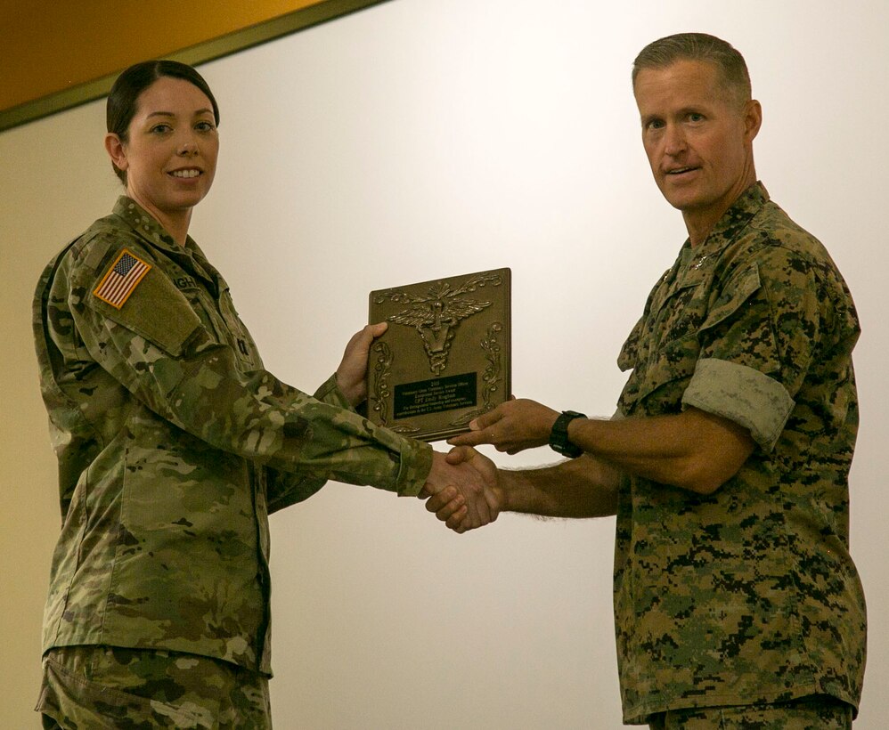 MARINE CORPS BASE CAMP LEJEUNE, N.C. – Major Gen. Carl E. Mundy III and U.S. Army Capt. Emily R. Bingham pose for a photo during an award ceremony aboard Marine Corps Base Camp Lejeune, N.C., July 29, 2016. Bingham received the 2016 U.S. Army Veterinary Corps Veterinary Services Officer Exceptional Service Award for serving as the MARSOC force veterinarian. This is the third MARSOC veterinarian in a row to receive this award. (U.S. Marine Corps photo by Cpl. Ryan C. Mains/ Released)