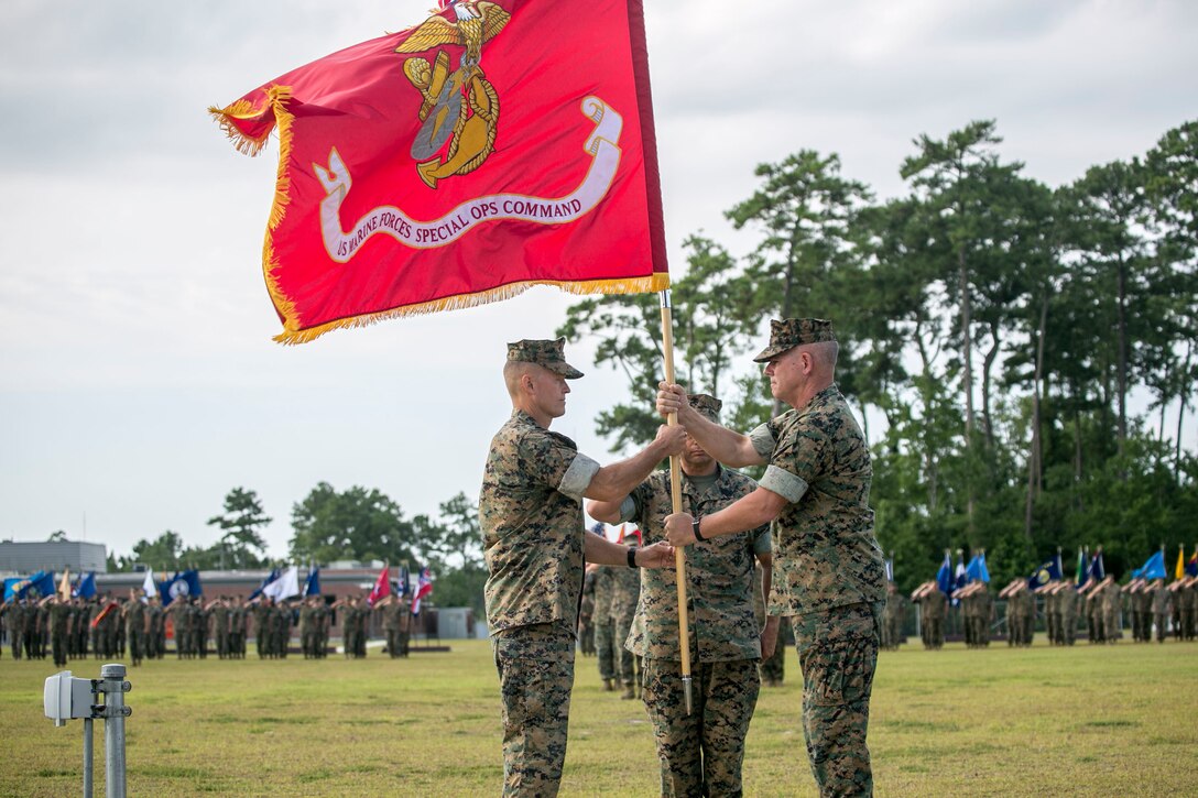 MARINE CORPS BASE CAMP LEJEUNE, N.C. – (Right to left) Major Gen. Joseph L. Osterman passes the Marine Corps colors to Maj. Gen. Carl E. Mundy III during a change of command ceremony aboard Marine Corps Base Camp Lejeune, N.C., July 26, 2016. The passing of the flag symbolizes Osterman relinquishing his responsibilities as the commanding general of U.S. Marine Corps Forces, Special Operations Command to Mundy. (U.S. Marine Corps photo by Cpl. Ryan C. Mains/ Released)