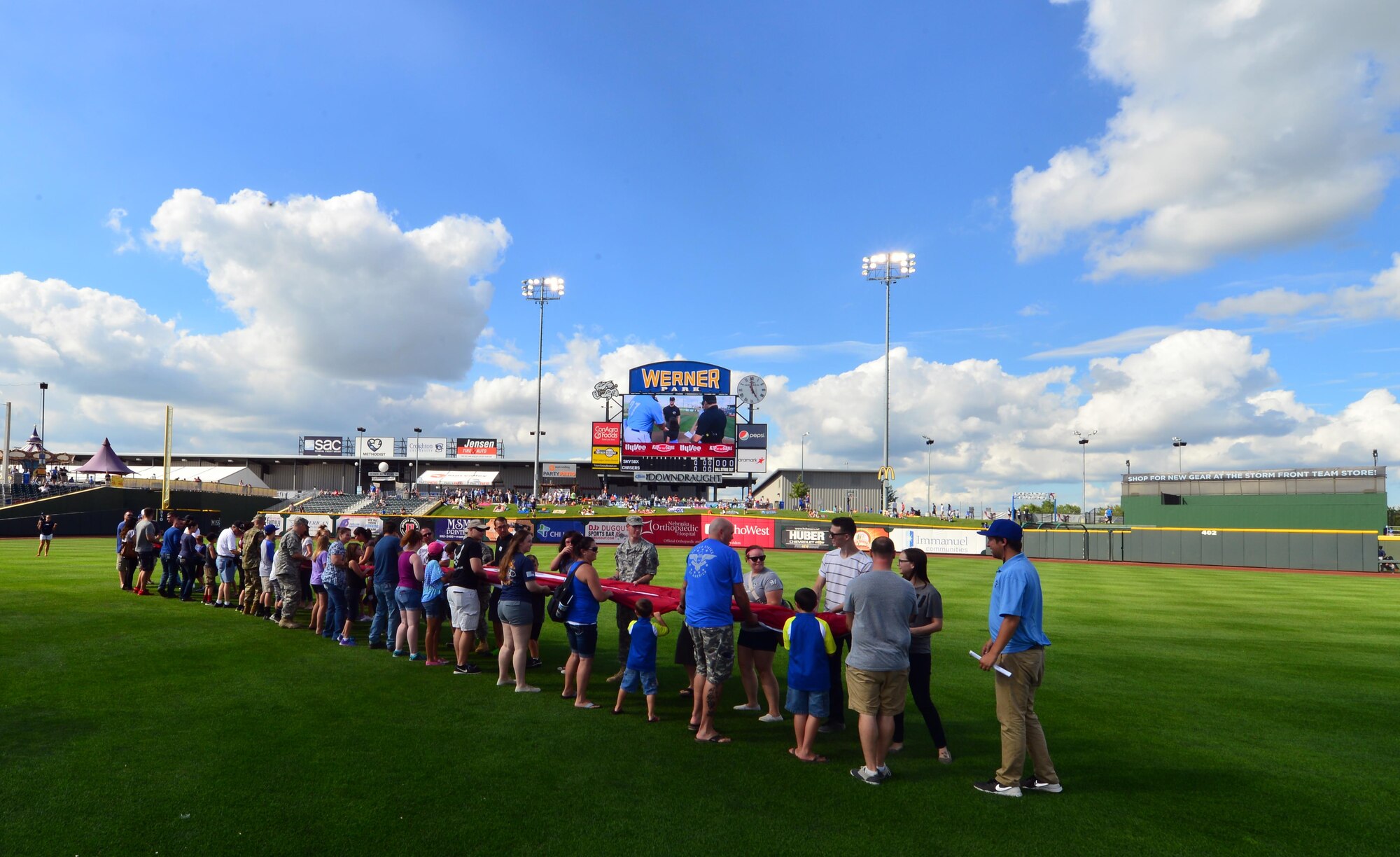 A giant-sized United States flag is unfurled in centerfield of Werner Park in Papillion, Neb. on Aug. 7 as part of a special military appreciation night. Werner Park is located near Offutt Air Force Base, Nebraska which employs more than 8,000 active-duty and civilian employees.  (U.S. Air Force photo by Josh Plueger)