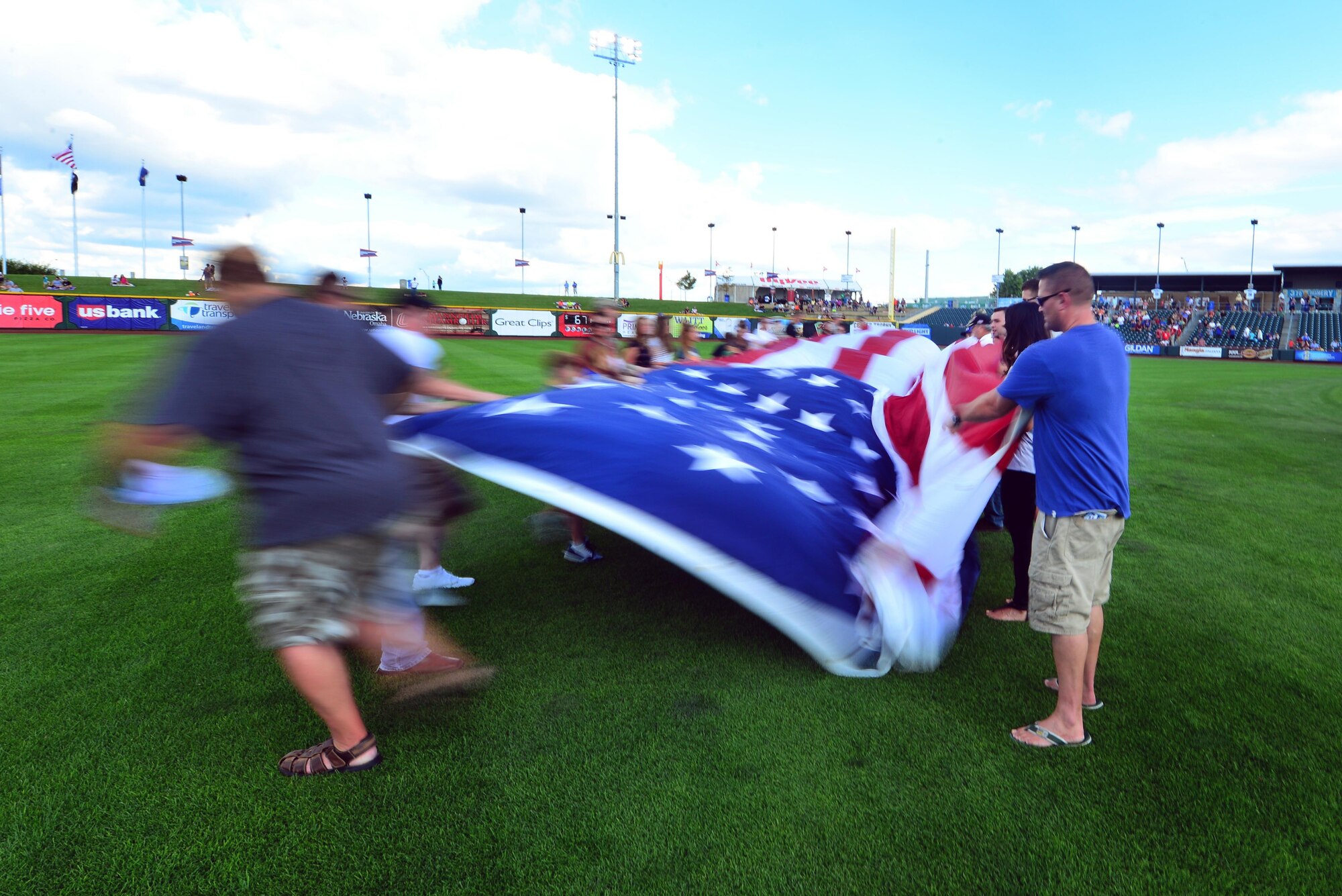 A giant-sized United States flag is unfurled in centerfield of Werner Park in Papillion, Neb. on Aug. 7 as part of a special military appreciation night. Werner Park is located near Offutt Air Force Base, Nebraska which employs more than 8,000 active-duty and civilian employees.  (U.S. Air Force photo by Josh Plueger)