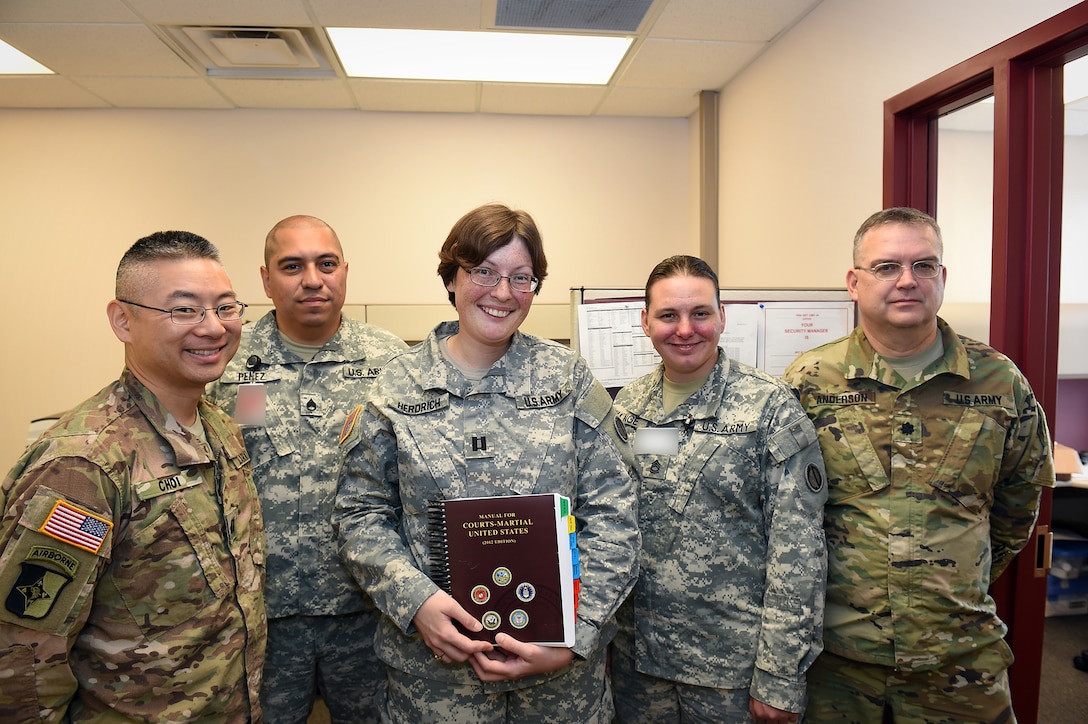 Army Reserve Capt. Jessica Herdrich, center, Trial Counsel, 85th Support Command, pauses for a photo with soldiers from her legal section during a battle assembly at the 85th Support Command. Herdrich is preparing for a yearlong deployment to Kuwait on a legal assistance mission to assist soldiers in the theater of operations.
(U.S. Army photo by Spc. David Lietz/Released)