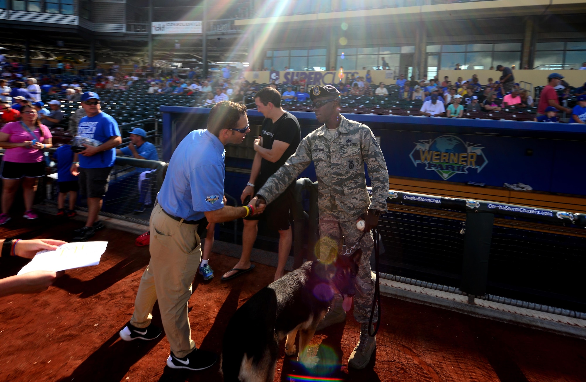 U.S. Air Force Staff Sgt. Elbert Foreman Jr., a military working dog handler, meets with staff members of the Omaha Storm Chasers baseball team during a military appreciation game held at Werner Park, Papillion, Neb. on Aug. 7.  Foreman and his dog Rocky ceremoniously place the game ball on the mound for the evening’s game.  (U.S. Air Force photo by Josh Plueger)