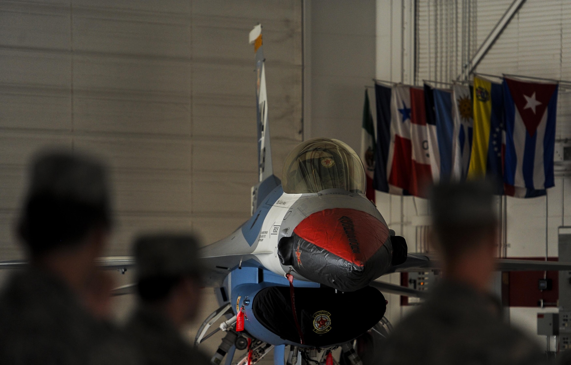 An F-16 Fighting Falcon, assigned to the 64th Aggressor Squadron, with the new “splinter” paint scheme sits in the U.S. Air Force Thunderbird hangar at Nellis Air Force Base, Nev., during the 57th Adversary Tactics Group change of command ceremony Aug. 5, 2016. The new paint scheme for the F-16 will serve as the closest representation of real world threats for pilots who train at Nellis AFB. (U.S. Air Force photo by Airman 1st Class Kevin Tanenbaum/Released)
