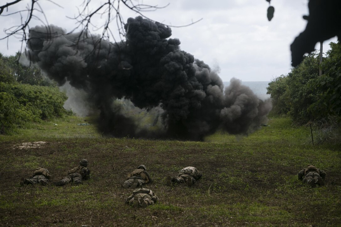 U.S. Marines and Tongan soldiers take cover while a demolition charge clears a path through concertina wire, July 28, 2016, during a live-fire range as part of a multi-national, bilateral exercise designed to increase interoperability and relations. The service members combined and applied skills practiced during the exercise in a culminating range such as high explosive exploitation, buddy rushing, demolition and beach insertion. The Marines are with Task Force Koa Moana and are originally assigned to I and III Marine Expeditionary Force. (U.S. Marine Corps photo by Cpl. William Hester/ Released)