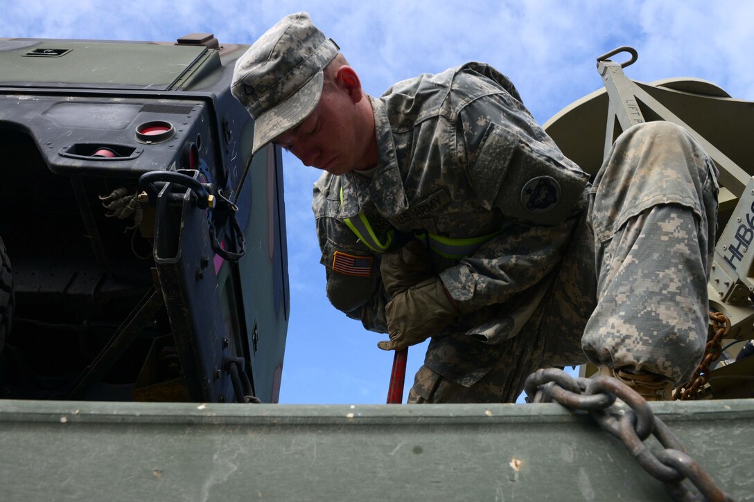 Pfc. Andrew Hartfield, a light transporter with the 539th Composite Truck Company from Fort Wainwright, Alaska, uses a load binder to secure a Humvee on a M915A5 Line-Haul Tractor Truck, in support of Polar Express at Joint Base Elmendorf-Richardson, Alaska, August 3, 2016. The M915A5 is used to rapidly transport containers and bulk supplies of transportation units from the ocean ports to the brigade support areas within the theater of operation. (U.S Air Force photo by Airman 1st Class Javier Alvarez)