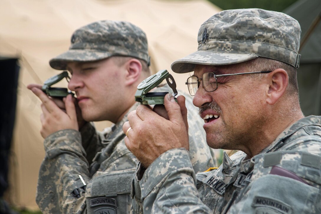 Two soldiers use lensatic compasses while participating in land navigation training during Vigilant Guard 2016 at Camp Ethan Allen Training Site, Jericho, Vt., July 28, 2016. Air National Guard photo by Airman 1st Class Jeffrey Tatro