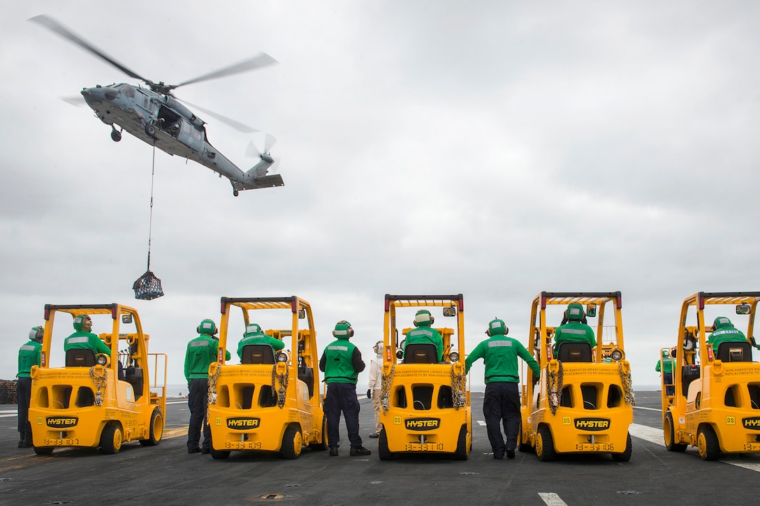 Sailors aboard the aircraft carrier USS Carl Vinson conduct a vertical replenishment with a SH-60 Seahawk helicopter in the Pacific Ocean, Aug. 3, 2016. The Vinson is underway with embarked Carrier Air Wing 2 and Destroyer Squadron 1 conducting the Tailored Ship's Training Availability and Final Evaluation Problem to prepare for their upcoming deployment. The Seahawk is assigned to assigned to Helicopter Sea Combat Squadron 4. Navy photo by Petty Officer 3rd Class Sean M. Castellano