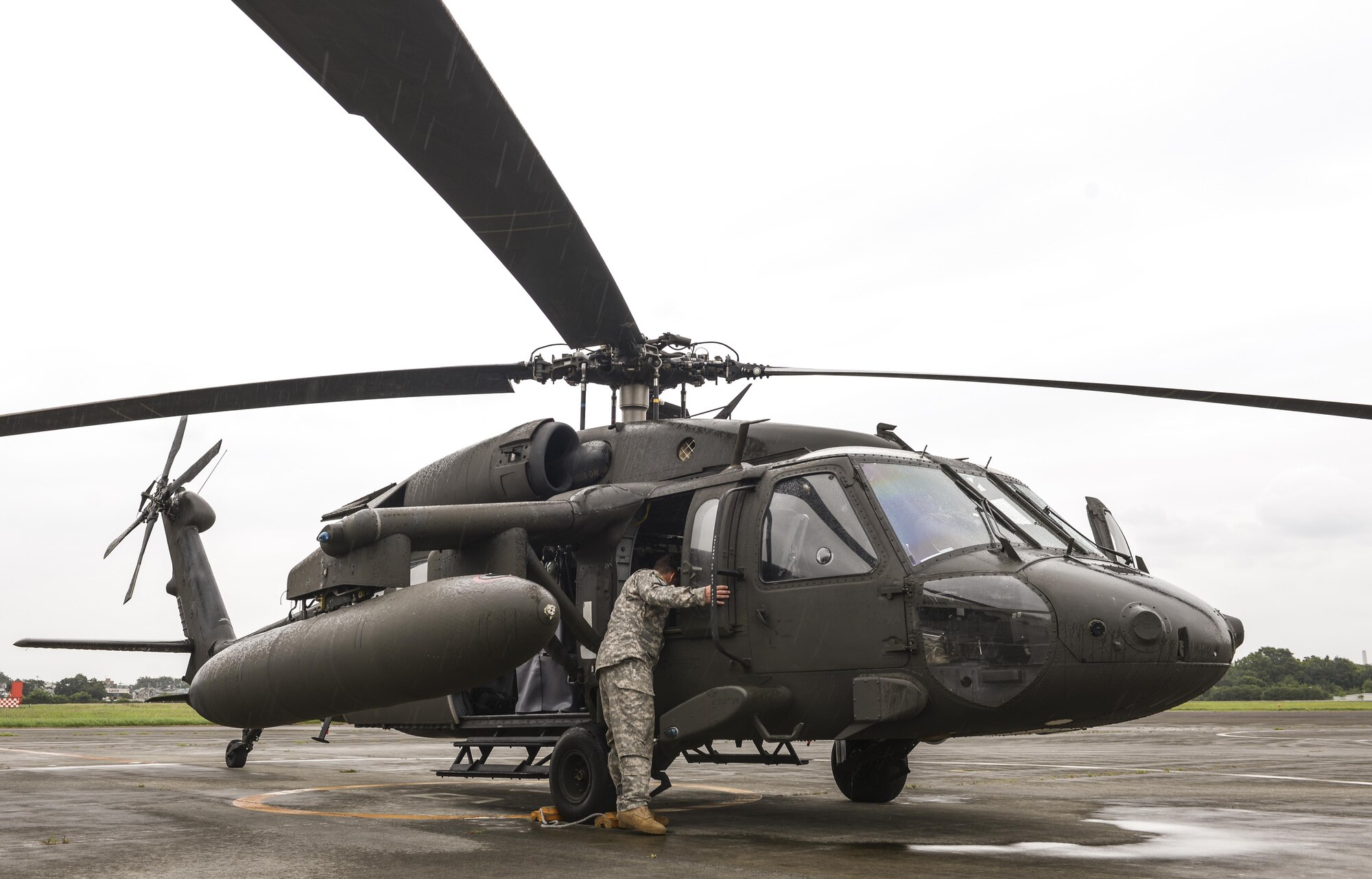 A member of the U.S. Army Aviation Battalion searches inside A UH-60 Blackhawk assigned to Camp Zama Army Base at Camp Tachikawa, July 26, 2016. Eastern Army Helicopter invited the U.S. Army Aviation Battalion to participate in the 2nd Tachikawa Helicopter Conference, in which a variety of U.S. and Japanese aviation professionals discussed a new disaster response strategy for helicopters. (U.S. Air Force photo by Airman 1st Class Elizabeth Baker/Released)