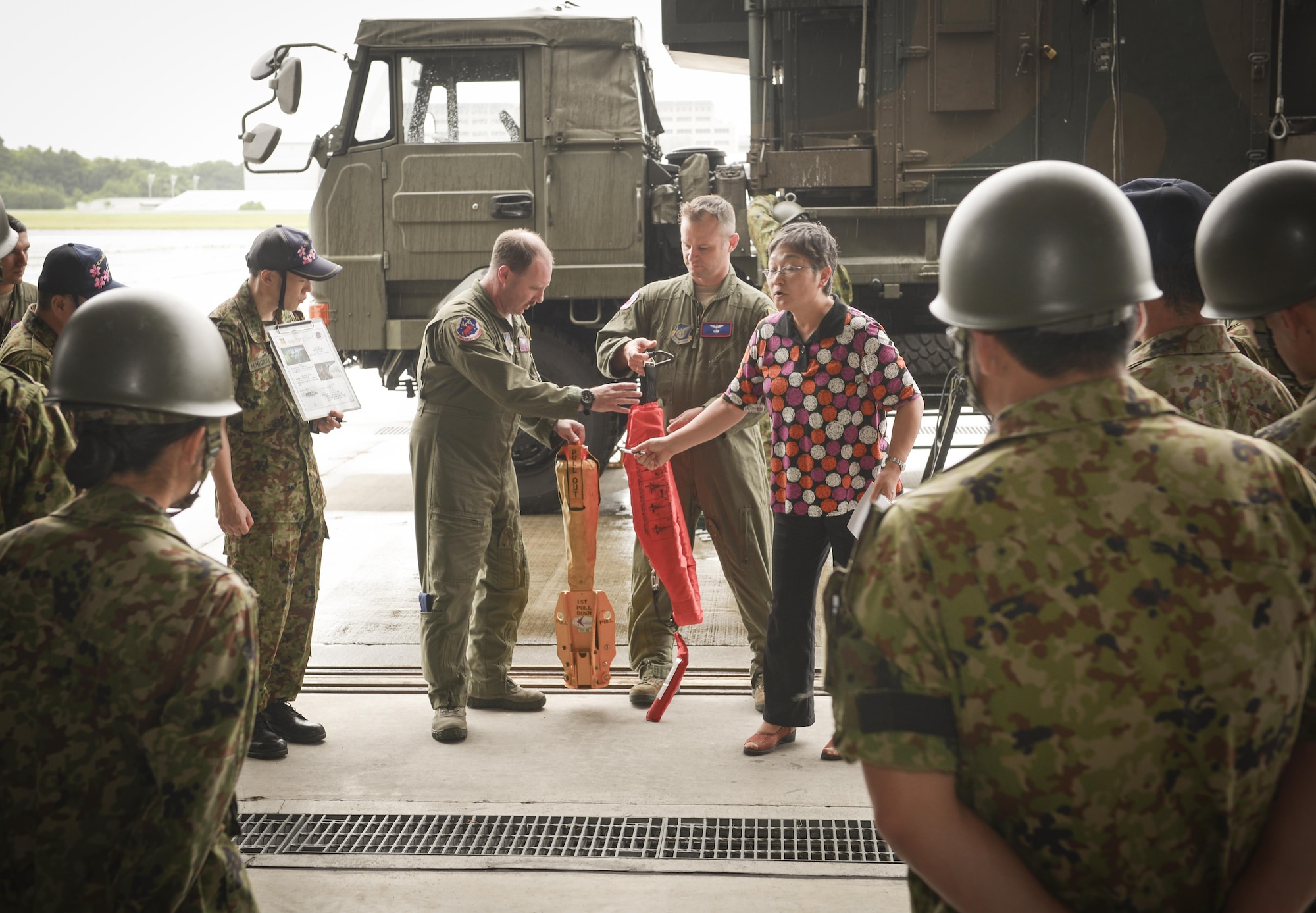 Tech. Sgt. David Jacobs, center left, 459th Airlift Squadron UH-1 Iroquois flight engineer, and Senior Master Sgt. Edward Spondenburg, 459 AS superintendent, demonstrate a forest penetrator to members of the Japan Ground Self-Defense Force with translation from Mitsuru Takahashi, 374th Airlift Wing chief of community relations at Camp Tachikawa, July 26, 2016. The 459 AS demonstrated their search and rescue capabilities, which supports Japan in disaster-response efforts.  (U.S. Air Force photo by Airman 1st Class Elizabeth Baker/Released)