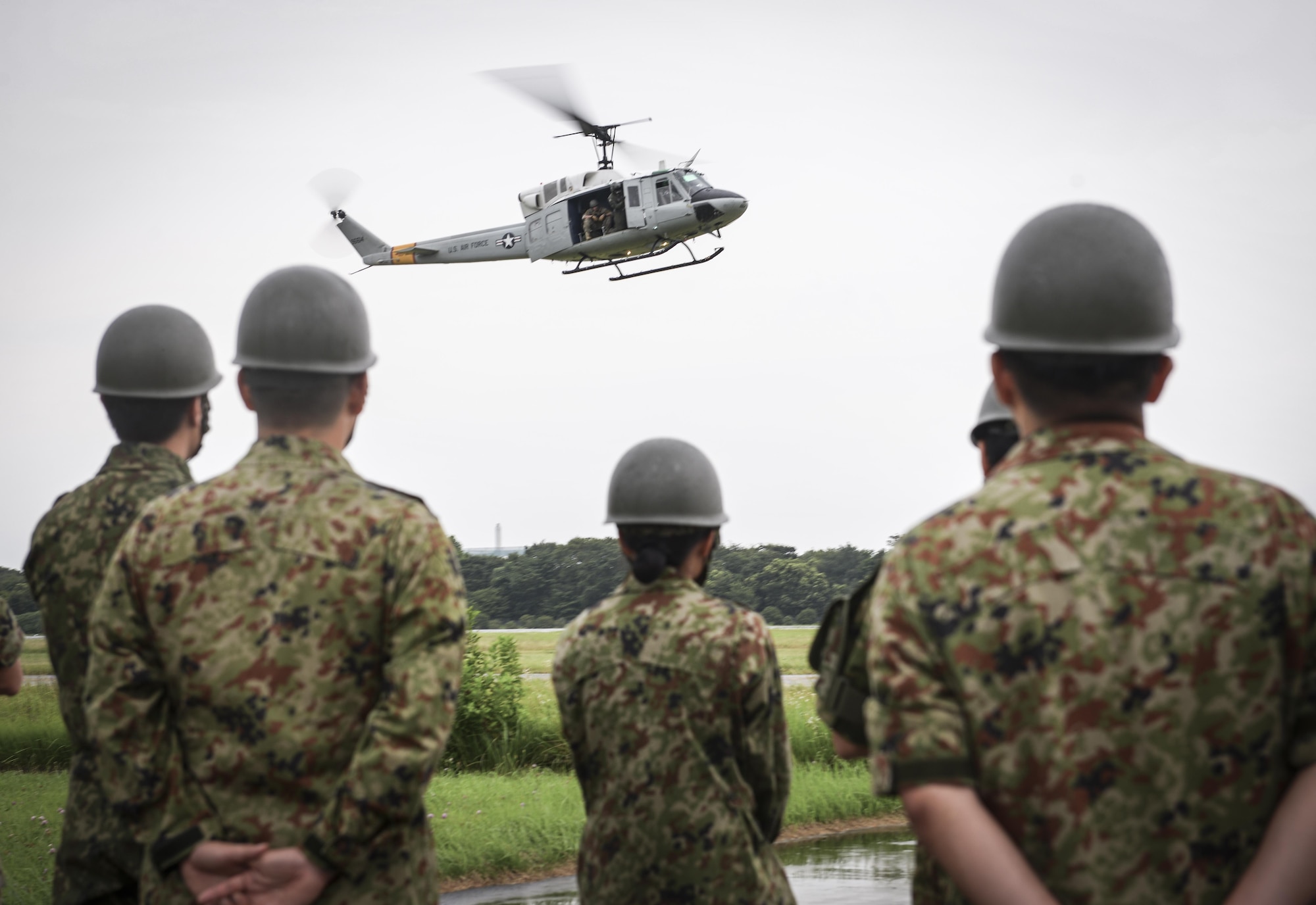 Members of the Japan Ground Self Defense Force watch the 459thth Airlift Squadron familiarize with a rescue operation at Camp Tachikawa, July 26, 2016. The 459 AS supports the government of Japan and Japan Self-Defense Force during emergency situations. (U.S. Air Force photo by Airman 1st Class Elizabeth Baker/Released)