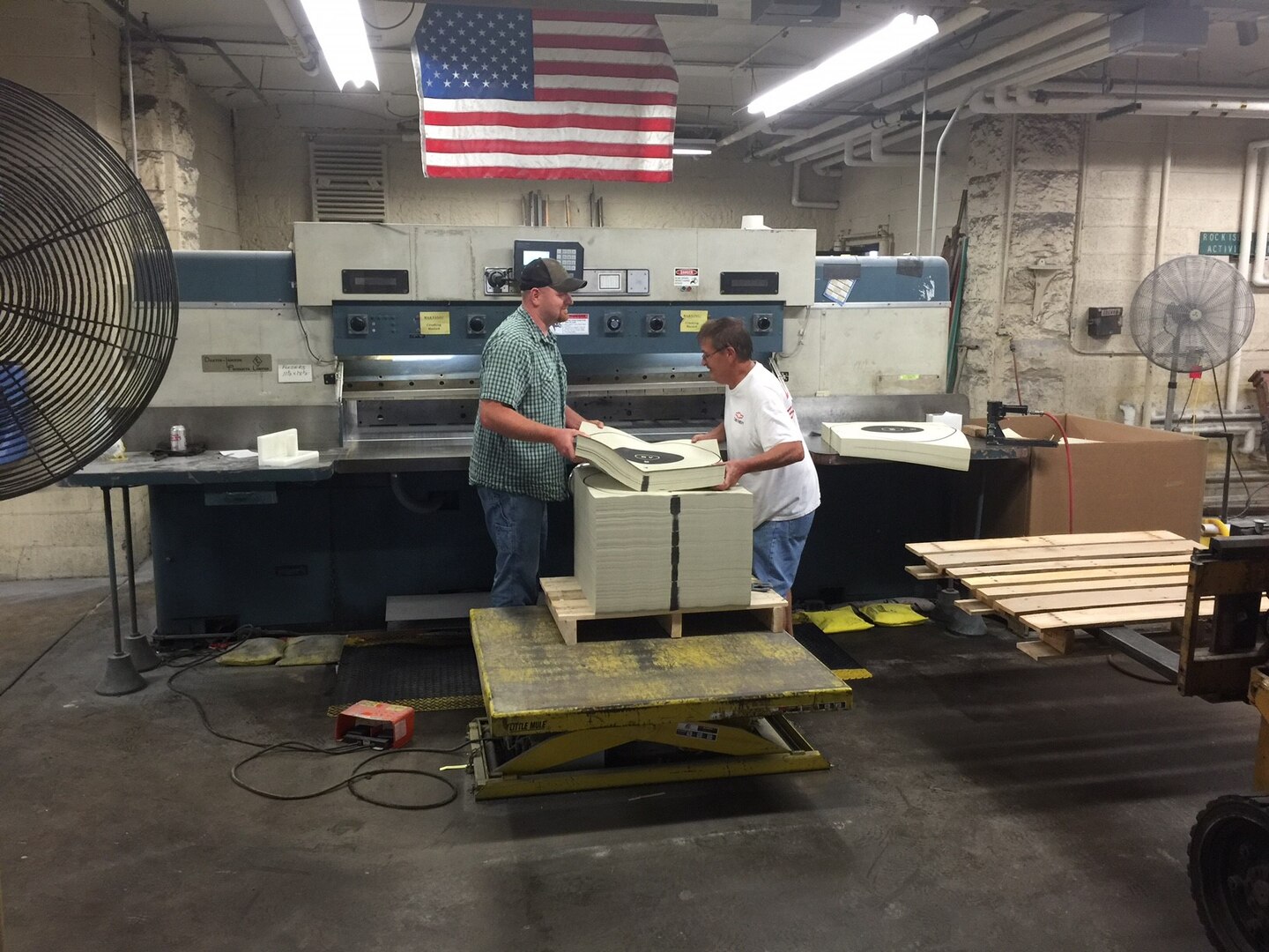 Jared Vogt (left) and Fred Power cut out targets on a Document Services large 102-inch paper cutter. 