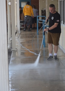 Damage Controlman 1st Class Joshua Stokes power washes a hallway at Oak Hill Academy in Jacksonville, Fla. Stokes, a Sailor with Southeast Regional Maintenance Center in Mayport, volunteered to help clean, assemble furniture and prepare classrooms for pre-K to 5th grade students with moderate to severe autism. SERMC provides surface ship maintenance, modernization and technical expertise in support of the ships of the US Navy. SERMC also provides visiting vessel services to foreign navies. Photo by Scott Curtis